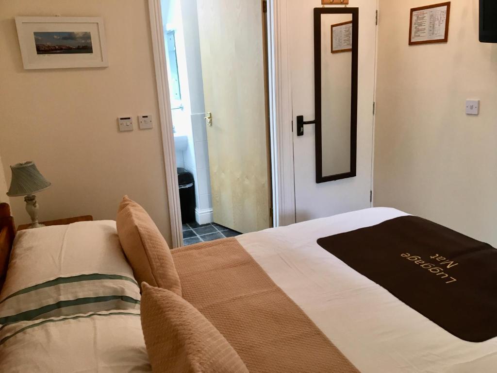 a bedroom with a bed with a black towel on it at Rosalie Guest House in Penzance