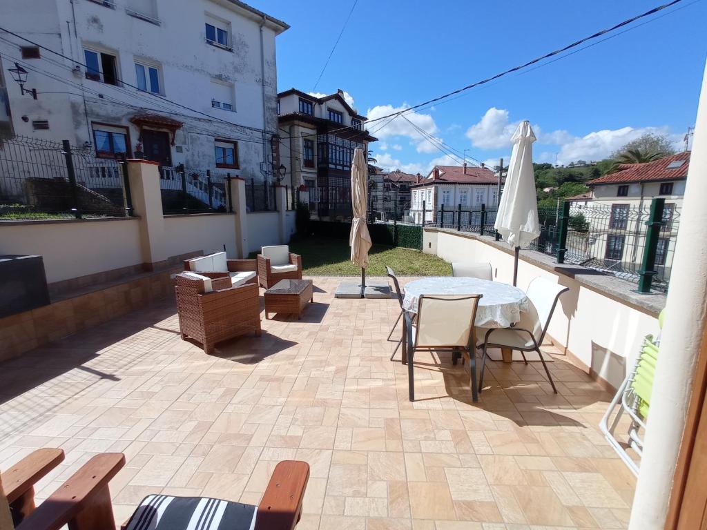 a patio with a table and chairs and an umbrella at Casa Santiago in Comillas