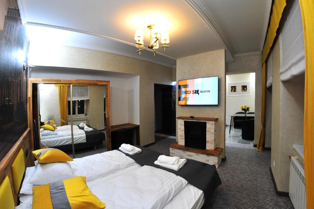 een hotelkamer met 2 bedden en een televisie bij APARTAMENTY NA MNISZEJ in Przemyśl