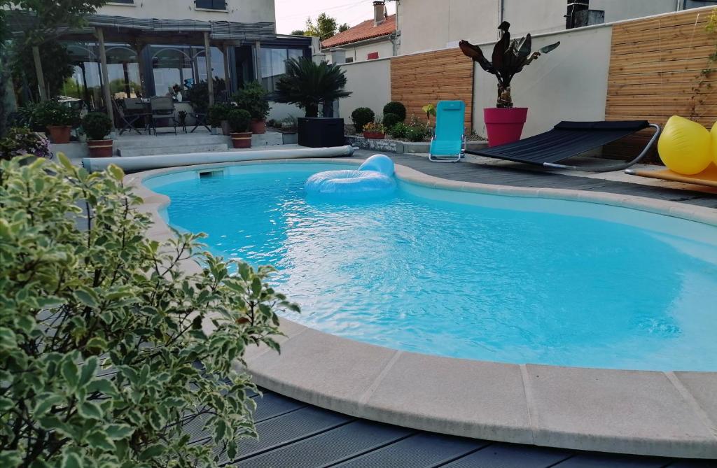 a swimming pool in a backyard with a blue poolvisor at La croix landolle in Châteaubernard