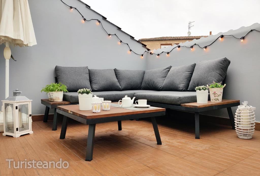 a living room with a couch and two tables at Dúplex Pleamar - Gran terraza en el centro in San Vicente de la Barquera