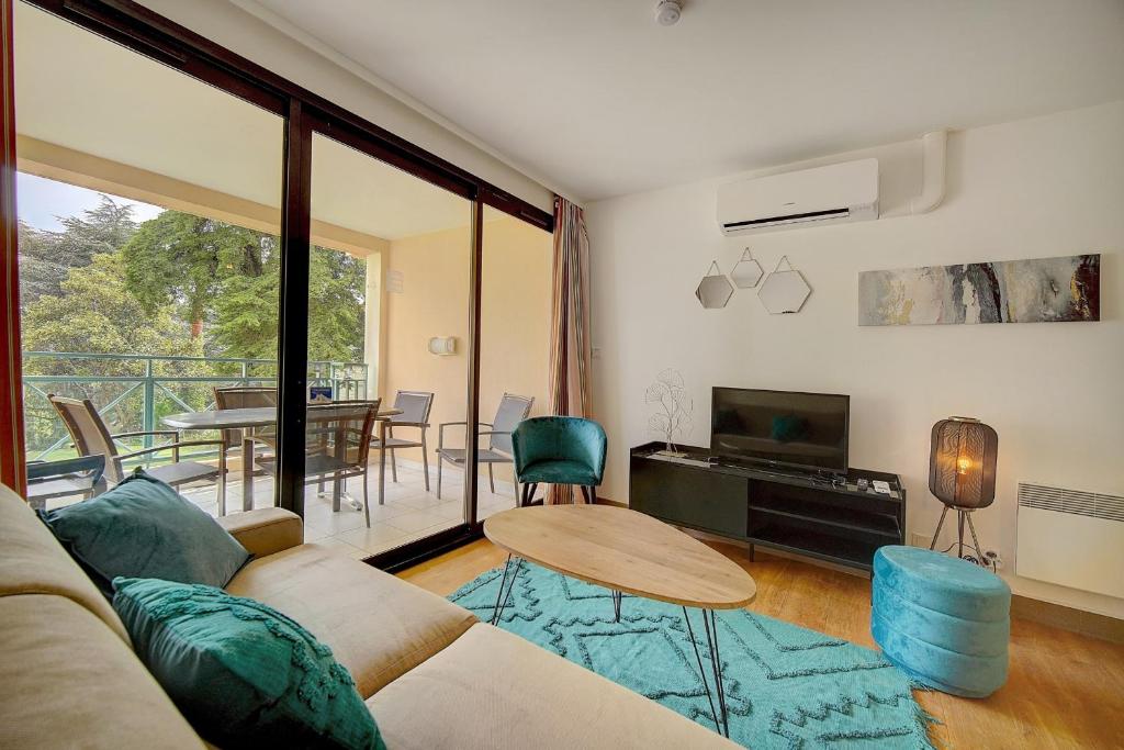un salon avec un canapé et une table dans l'établissement IMMOGROOM - 3 Rooms - Renovated - Pool - Air conditioning - Parking -, à Cannes