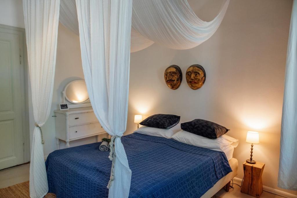 um quarto com duas camas e duas máscaras na parede em Káli44 Vendégház em Révfülöp