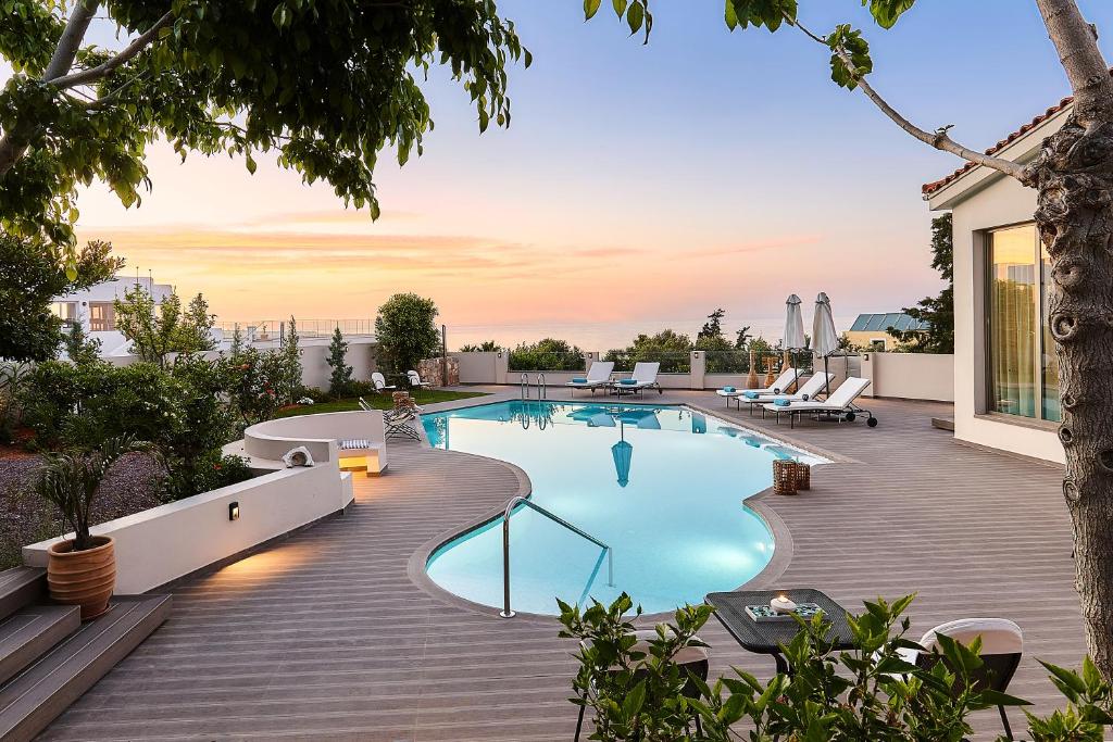 uma piscina num deque ao lado de uma casa em Grace Villas Collection em Hersonissos