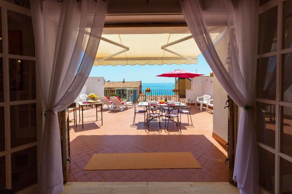 una porta aperta su un patio con tavolo e sedie di Siciliabedda Naxos a Giardini Naxos