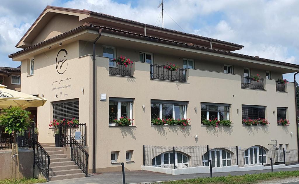 un gran edificio con flores en las ventanas en Gostilna s prenočišči Pri Janezu, en Zgornja Ložnica