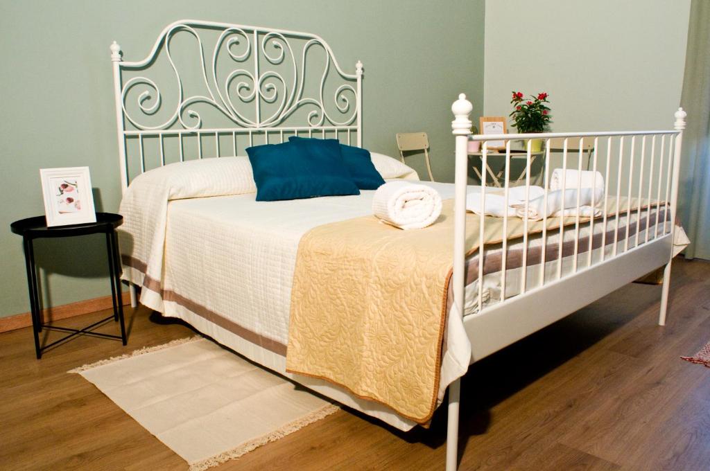 ein Schlafzimmer mit einem weißen Bett mit blauen Kissen in der Unterkunft B&B Affittacamere Trigona in Misterbianco