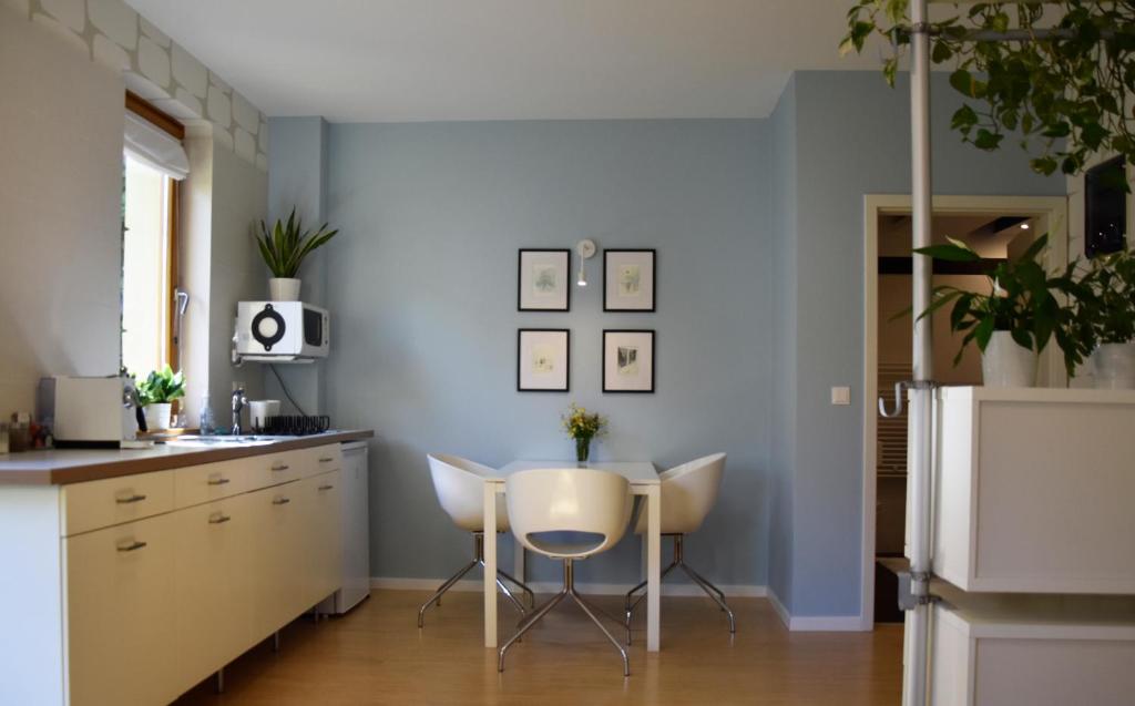 STM3 Apartman في بيتْش: مطبخ مع طاولة وكراسي بيضاء