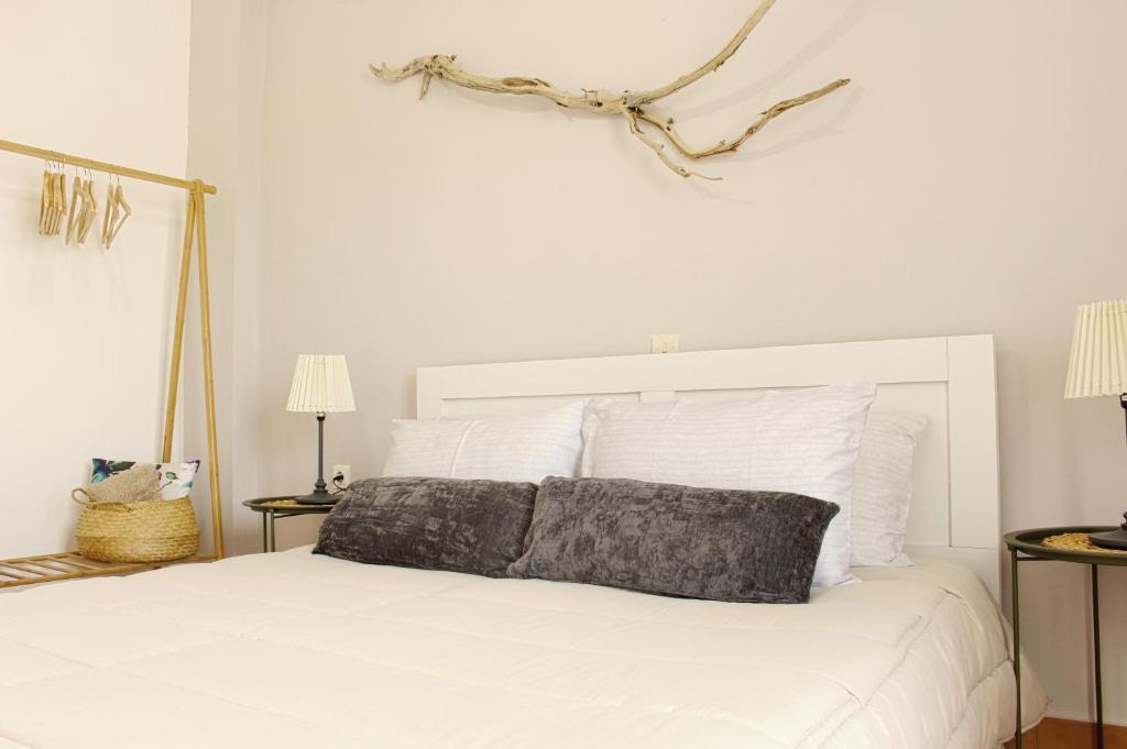 ein weißes Bett mit einem grauen Kissen darüber in der Unterkunft Ayerina First floor Apartment in Arillas