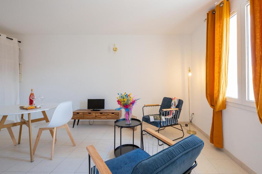 a living room with a blue couch and chairs at Hôtel & Résidence San Roccu in Saint-Florent