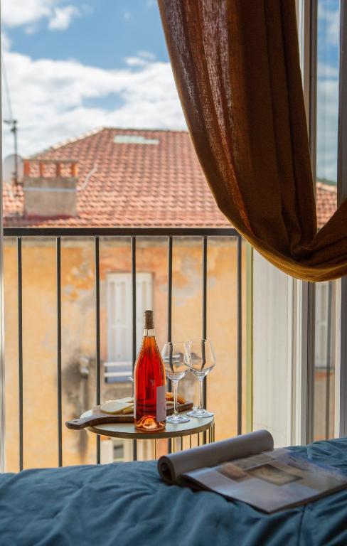 a table with two glasses and a bottle of wine at Hôtel & Résidence San Roccu in Saint-Florent