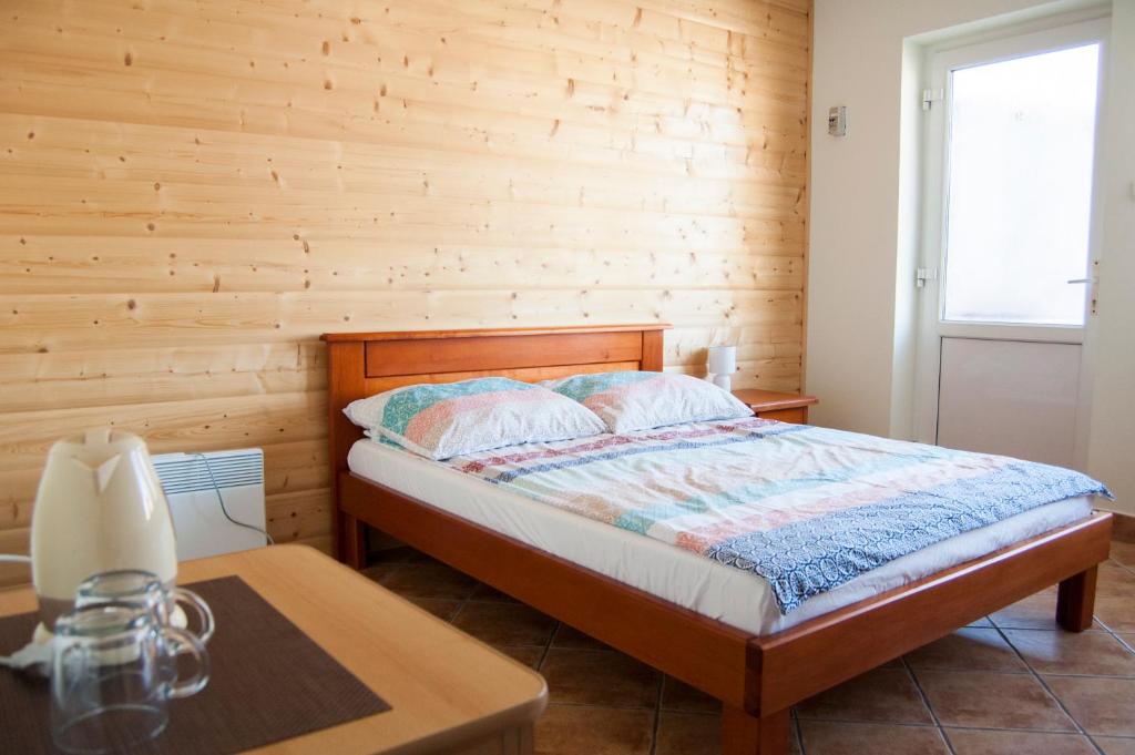 a bedroom with a bed and a wooden wall at Bed and Bread in Łeba