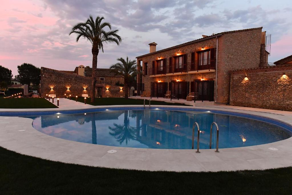 une grande piscine en face d'une maison dans l'établissement Hotel Aires de l'Emporda, à Vilacolum