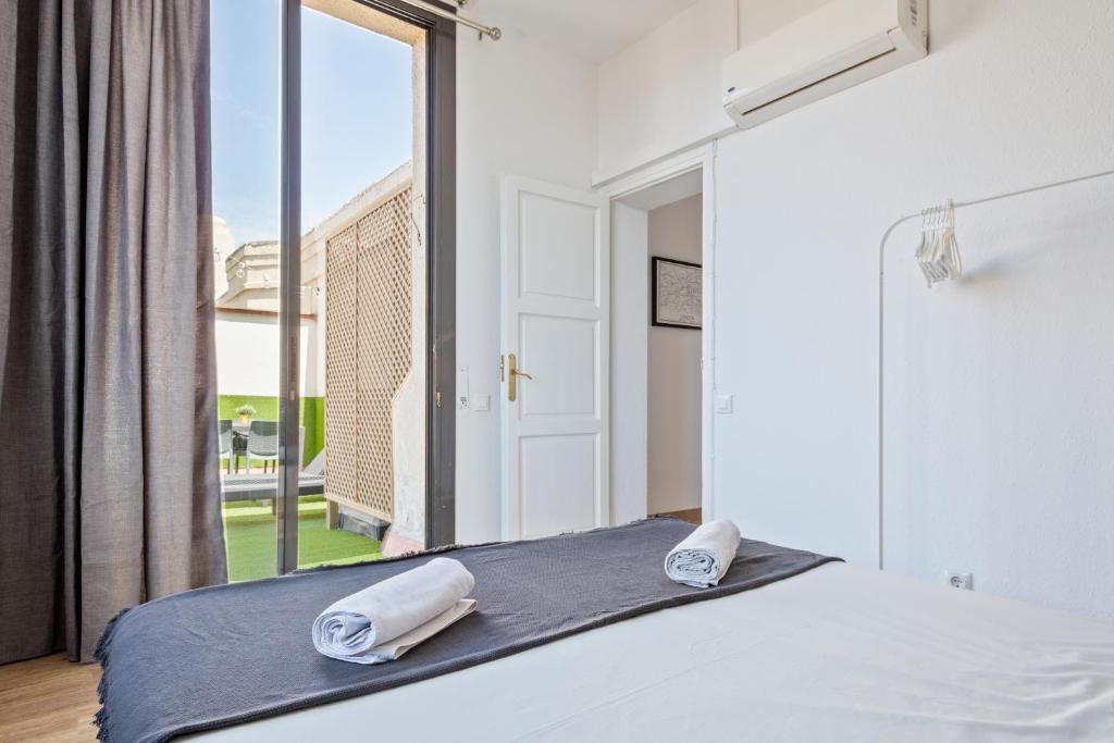 a bedroom with a bed with two towels on it at Blau Atic Apartment in Barcelona