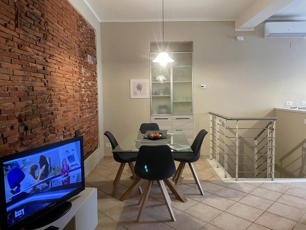 a living room with a dining table and a tv at Corte Navari - Italo's Home in Pietrasanta