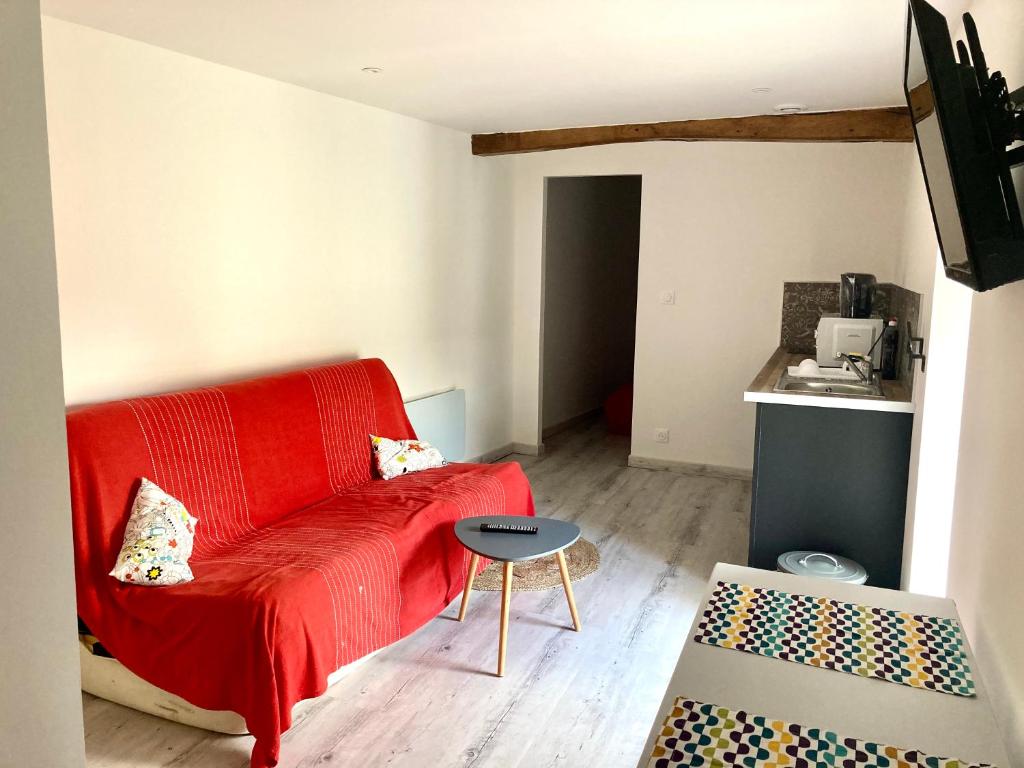 a living room with a red couch and a table at Bel Air 1 in Fougeré