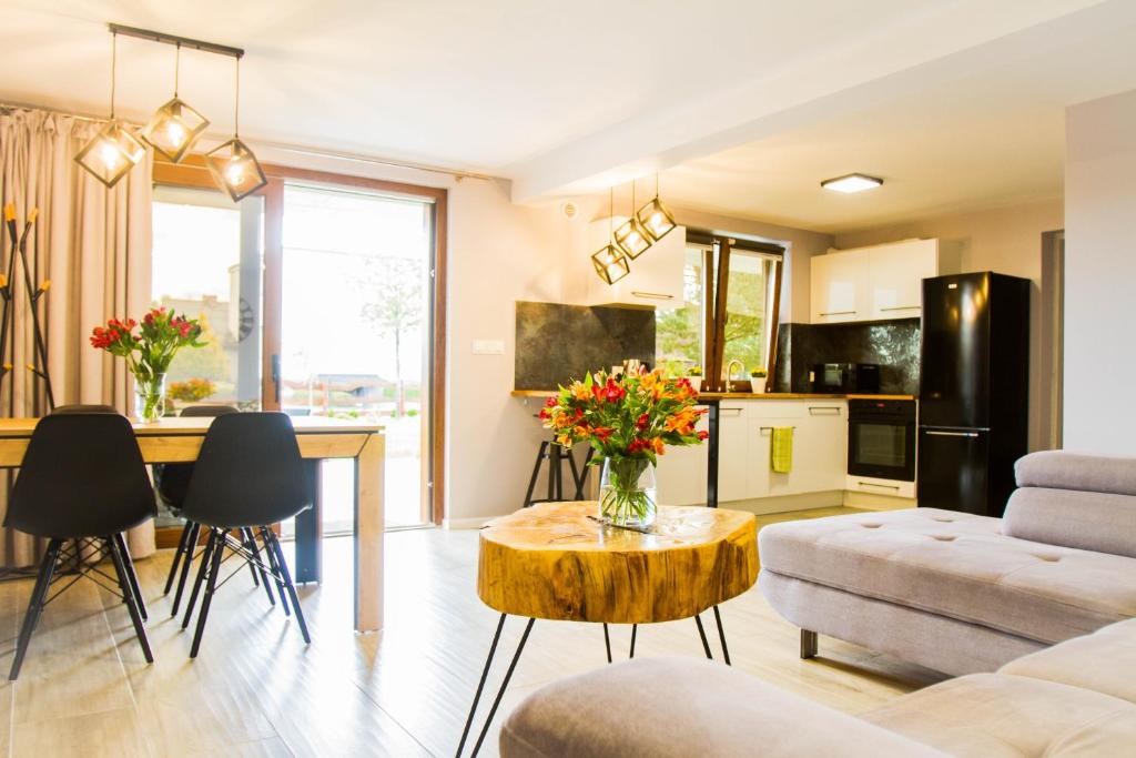 a living room with a couch and a table with flowers on it at Sworne Zacisze in Swornegacie