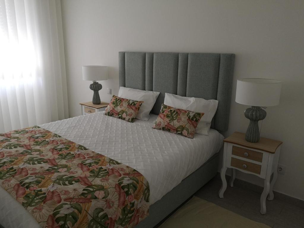 um quarto com uma cama grande e 2 mesas de cabeceira em Casinha D'Avó na Nazaré