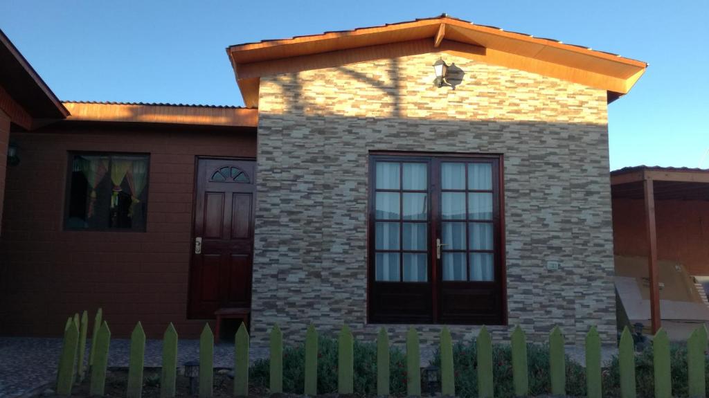 una casa con una valla delante de ella en TIK'A WASI SUP, en San Pedro de Atacama