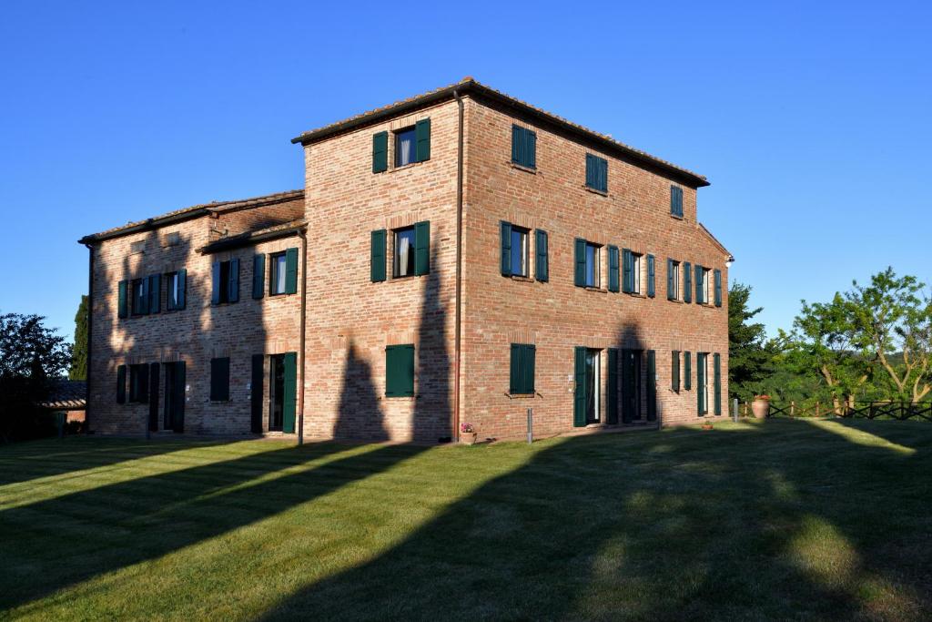 an old brick building with a large grass yard at Porsenna Resort in Villastrada