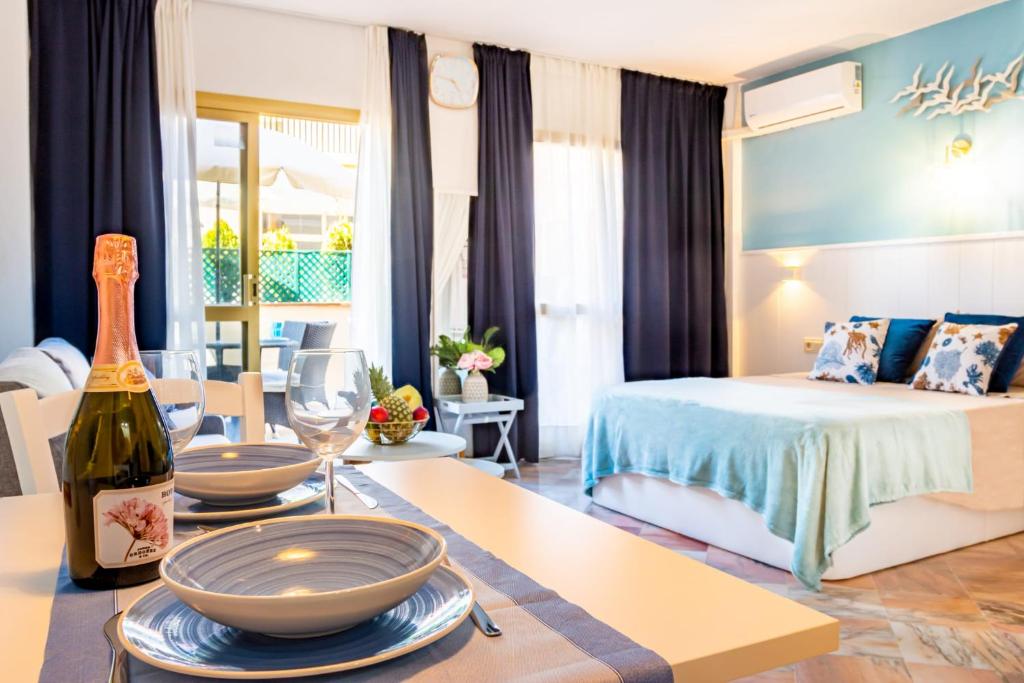 soggiorno con letto e tavolo con bottiglia di vino di Lovely and Quiet Marbella a Marbella