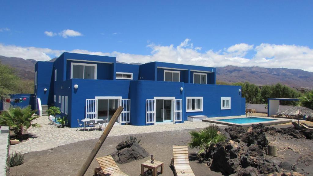 une maison bleue avec une piscine en face de celle-ci dans l'établissement Cap-Azul, à Porto Novo