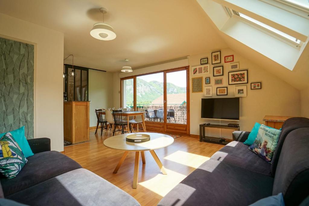 uma sala de estar com um sofá e uma mesa em Les Aravis - Apartment for 6 people 5min from the lake em Giez