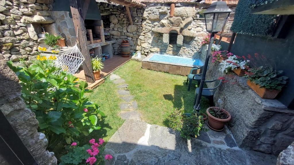 an outdoor garden with a swimming pool and flowers at Casa en el rural de Galicia, A Forneira in Leiro