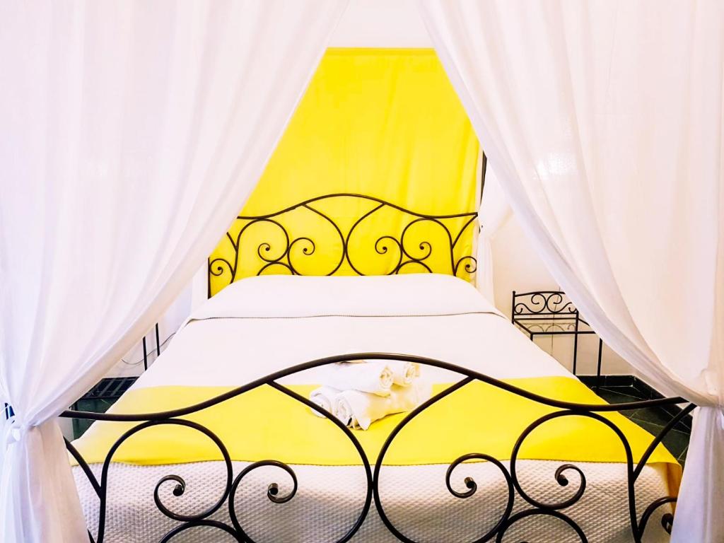 アルゲーロにあるBig Fish Alghero Guesthouseの黄色のベッド