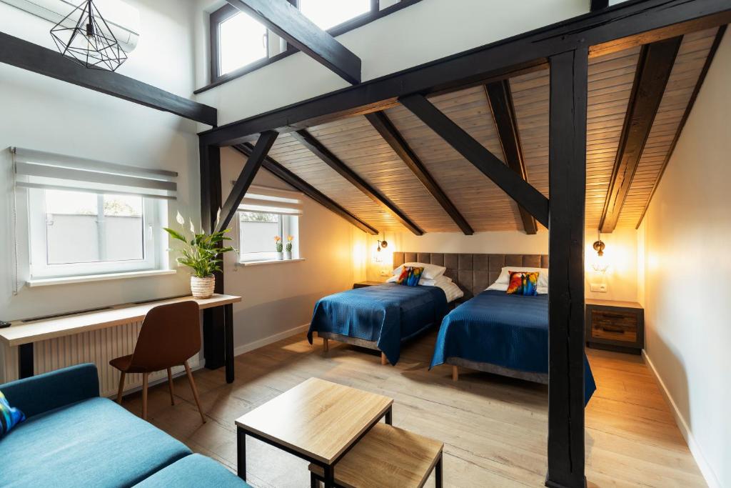 Dormitorio tipo loft con 2 camas y sofá en Villa Toscania-check in 24h, en Poznan