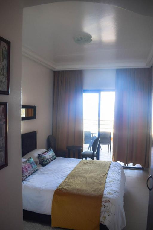 a hotel room with a bed and a large window at Auberge Oualidia Dream in Oualidia