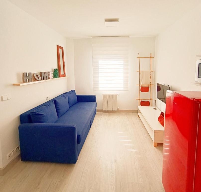 uma sala de estar com um sofá azul num quarto em La Casita del abuelo Javi em Cambados