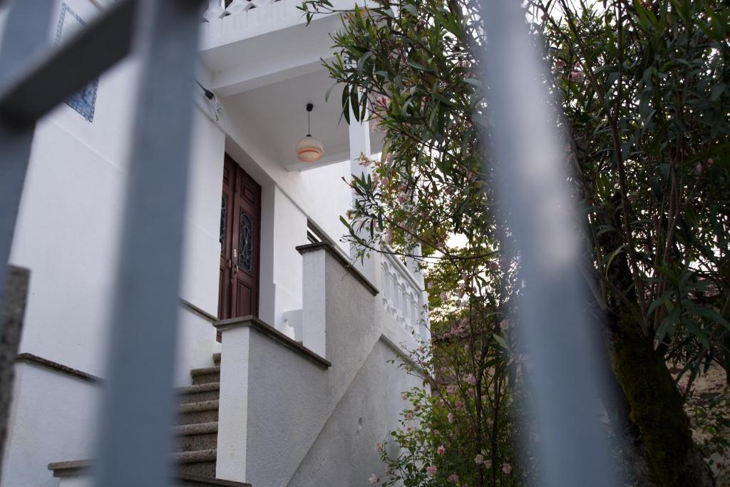 a white house with a staircase and a window at Hospedagem Dona Rosalina in Seia