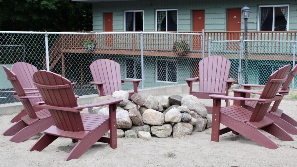 tres sillas sentadas frente a un montón de rocas en Motel Montreal, en Lake George