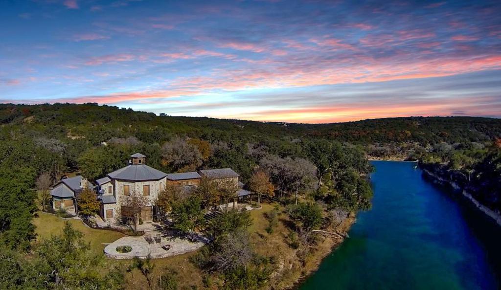 an aerial view of a house next to a river at Lejos in Wimberley