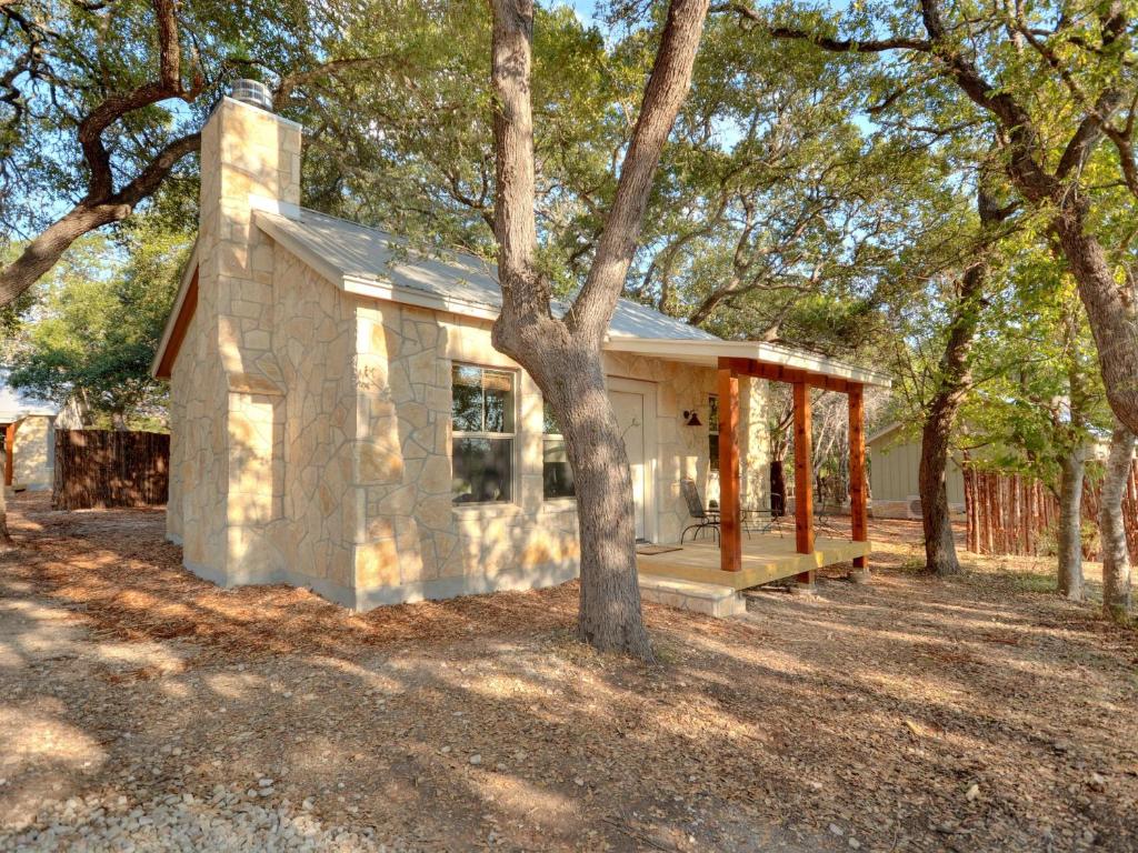 a small house with a tree in front of it at Cabins at Flite Acres - Desert Willow in Wimberley