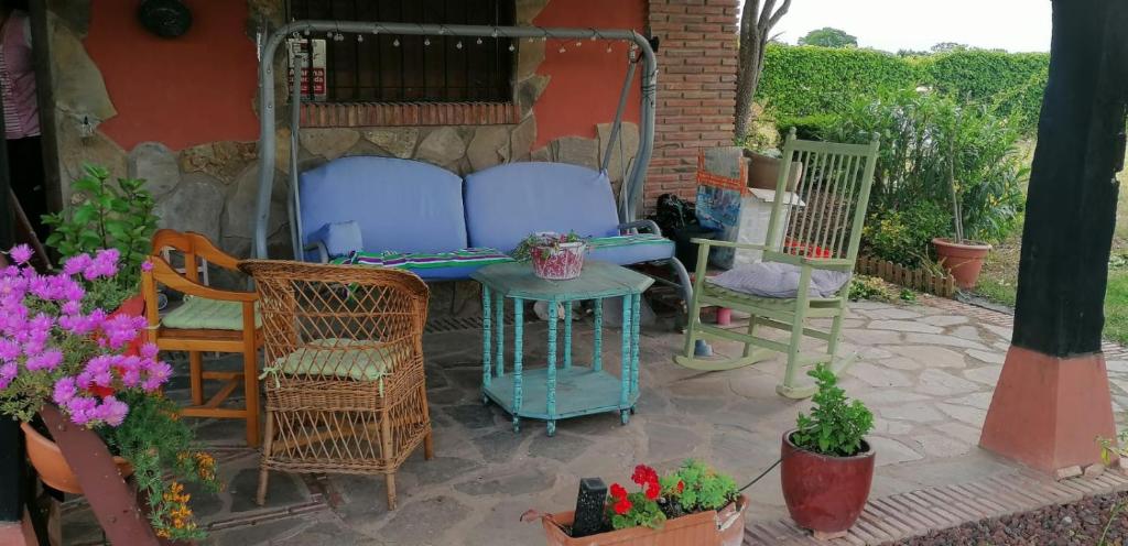 un patio con sillas, una mesa y algunas flores en La Sartén, en Lardero