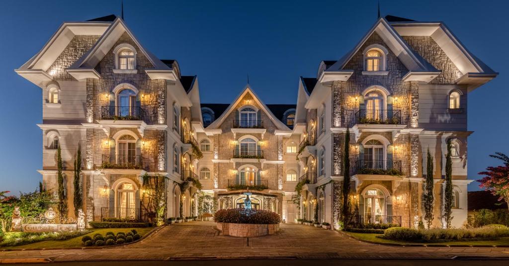 uma casa grande com luzes acesas à noite em Hotel Colline de France em Gramado