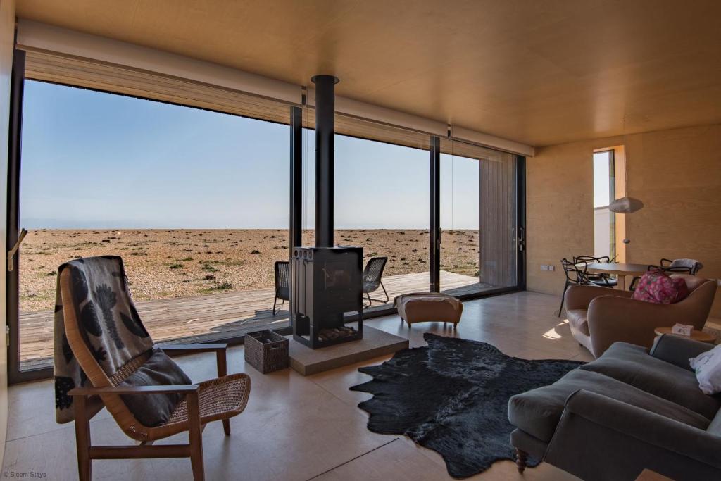 a living room with a couch and a fireplace with a view at El Ray by Bloom Stays in Dungeness