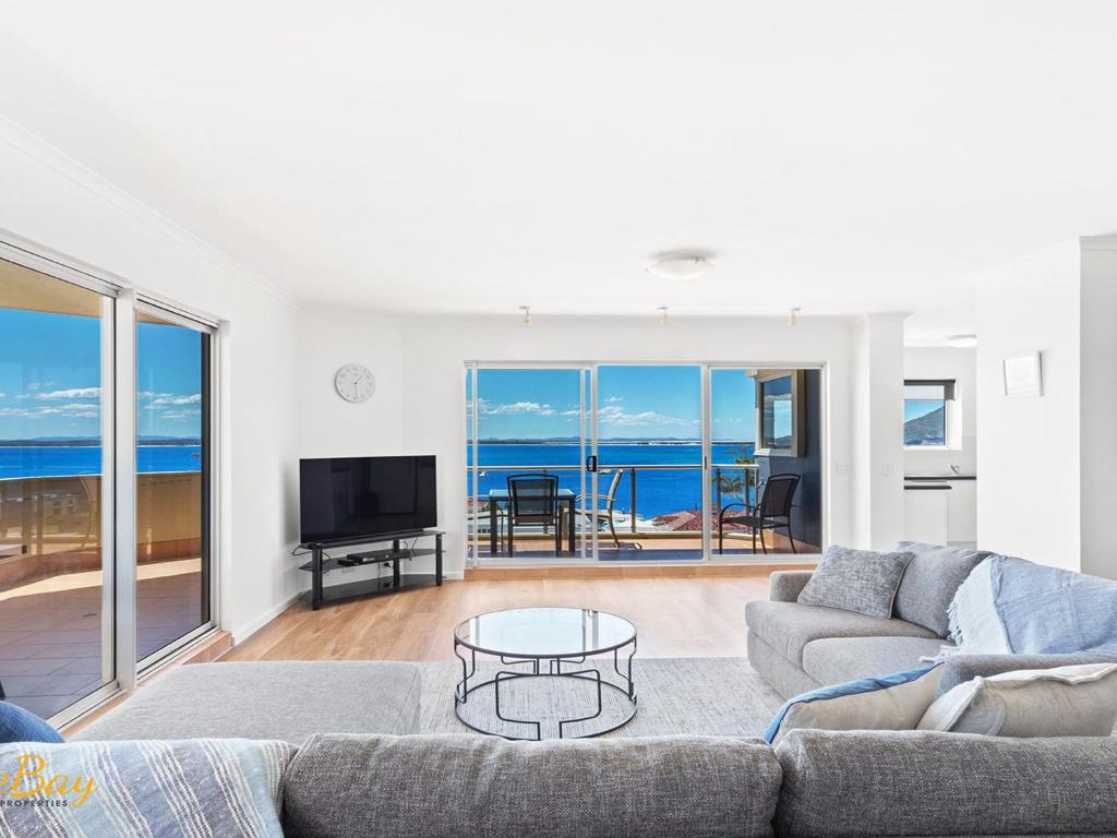 a living room with a couch and a table at Breakwater Apartment 402 in Shoal Bay