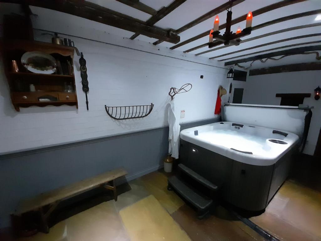 a bathroom with a bath tub and a sink at Stable cottage cozy,quirky with a hot tub in Bridlington