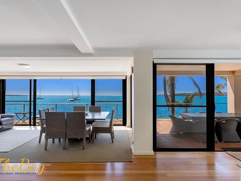 a dining room with a table and a view of the ocean at Wanda Beach Unit 2 Soldiers Point Road in Salamander Bay