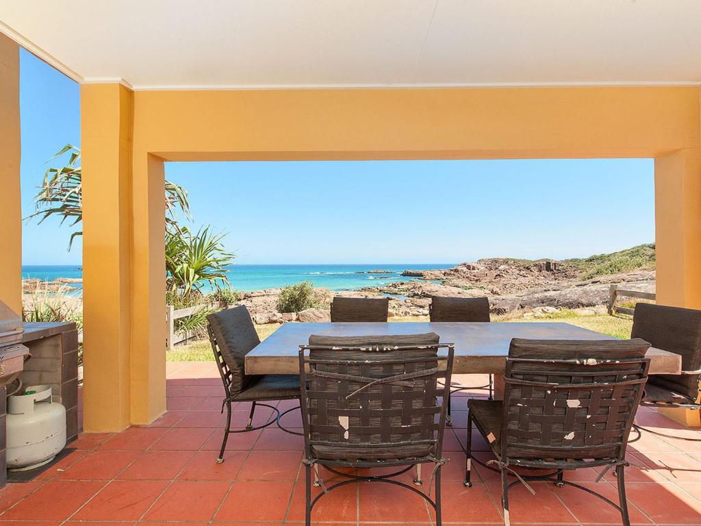 a patio with a table and chairs and the ocean at Birubi Point Anna Bay 17A in Anna Bay