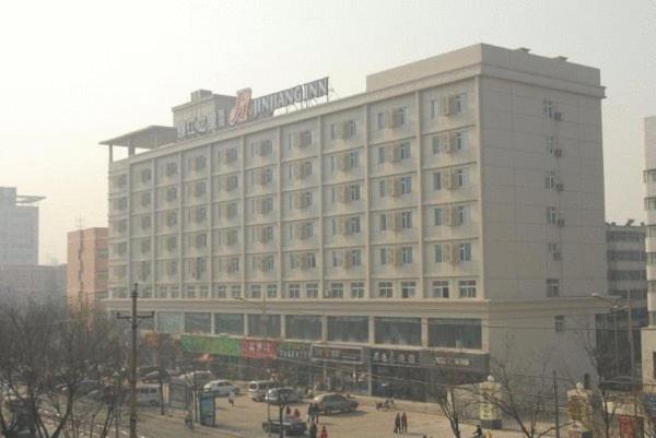 un grande edificio bianco con un cartello sopra di Jinjiang Inn - Zhengzhou Wenhua Road a Zhengzhou
