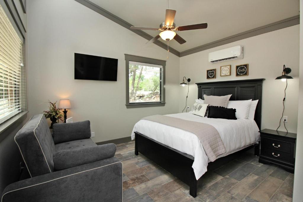 a bedroom with a bed and a chair and a ceiling fan at Green Acres Cottages - Blanco Suite in Wimberley