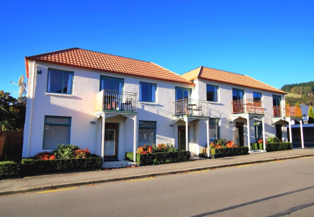 a row of white houses on the side of a street w obiekcie Les Troupes Apartments w mieście Akaroa