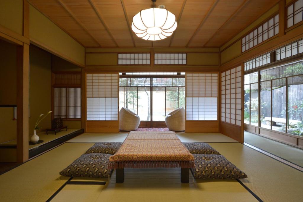 a room with a table in a room with windows at Jeugiya in Kyoto