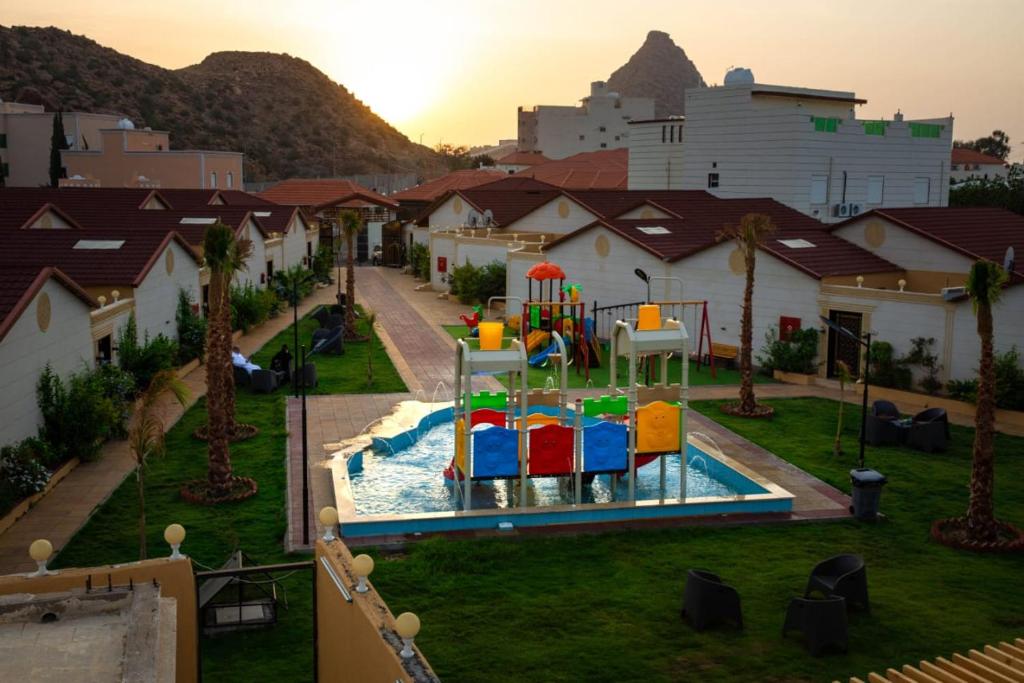 un parque infantil con un tobogán de agua en منتجع جزيرة الروز بالهدا en Al Qubsah