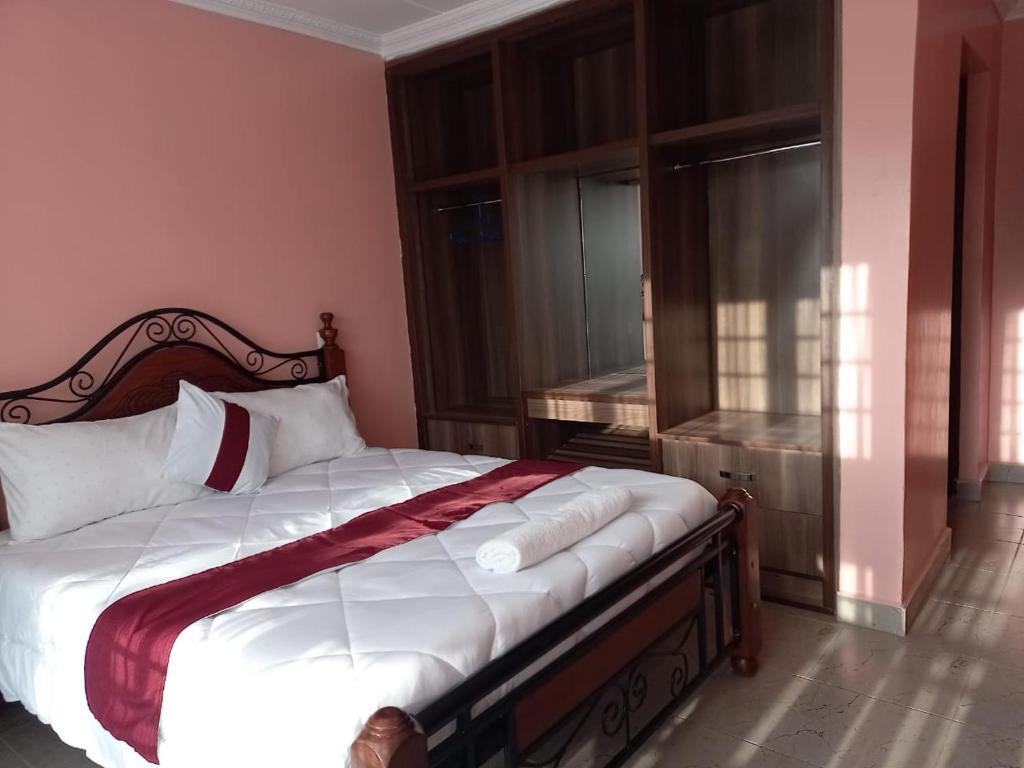 a bedroom with a bed with white sheets and a window at El Sueno Homestay in Naivasha