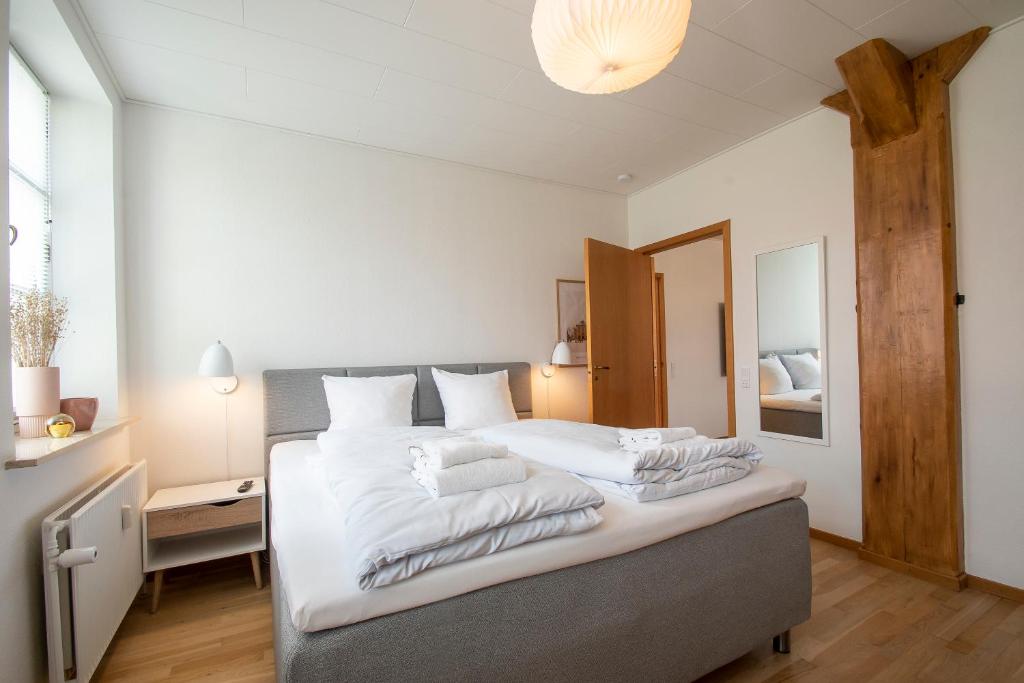 - une chambre avec un grand lit et des draps blancs dans l'établissement Exclusive 2 Bedroom Apartment, à Sønderborg